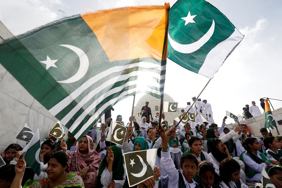 Attendees wave Pakistan's national flag and Kashmir's flag, to express solidarity with the people of Kashmir, at the Mausoleum of Muhammad Ali Jinnah. (Photo: Akhtar Soomro / REUTERS)
