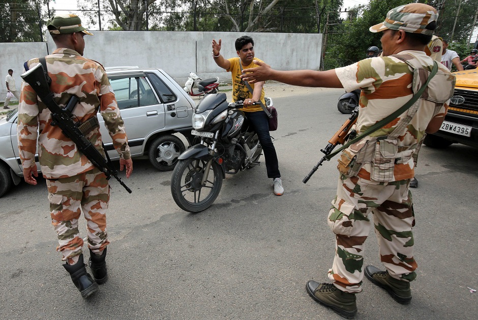 Members of Central Industrial Security Force (CISF) stop a man at a check point along a road during restrictions in Jammu August 6, 2019. (Photo: REUTERS/Mukesh Gupta)
