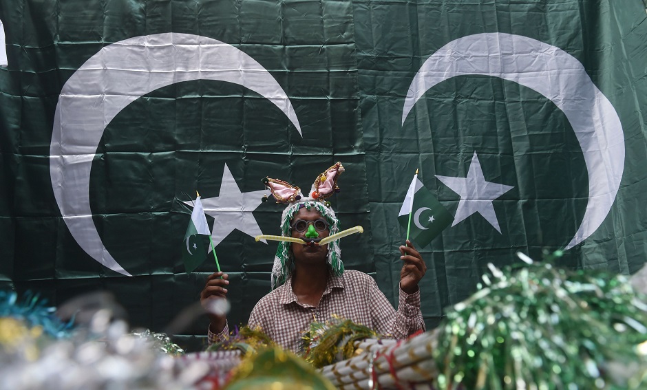 A vendor holds Pakistani national flags as he waits for customers at a market in preparation for Independence Day celebration in Lahore. (Photo: Arif Ali / AFP)