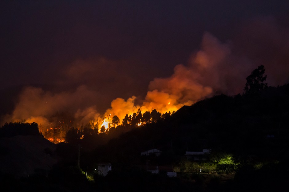 Flames and smoke from a forest fire are seen in the village of Moya, in the Canary Island of Gran Canaria, Spain. PHOTO: REUTERS