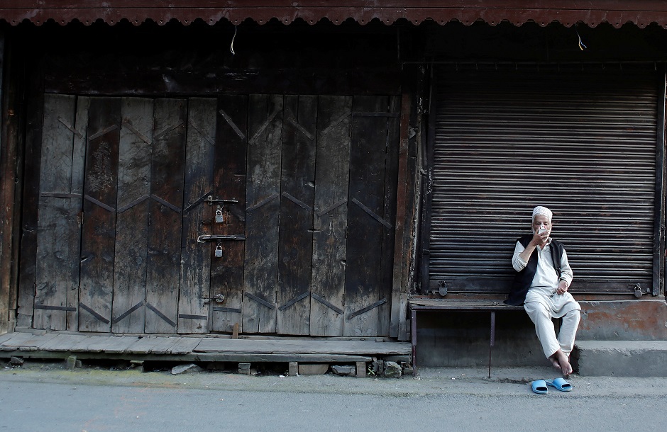 A Kashmiri man drinks tea as he sits outside closed shops during restrictions after scrapping of the special constitutional status for Kashmir by the Indian government. PHOTO: REUTERS 
