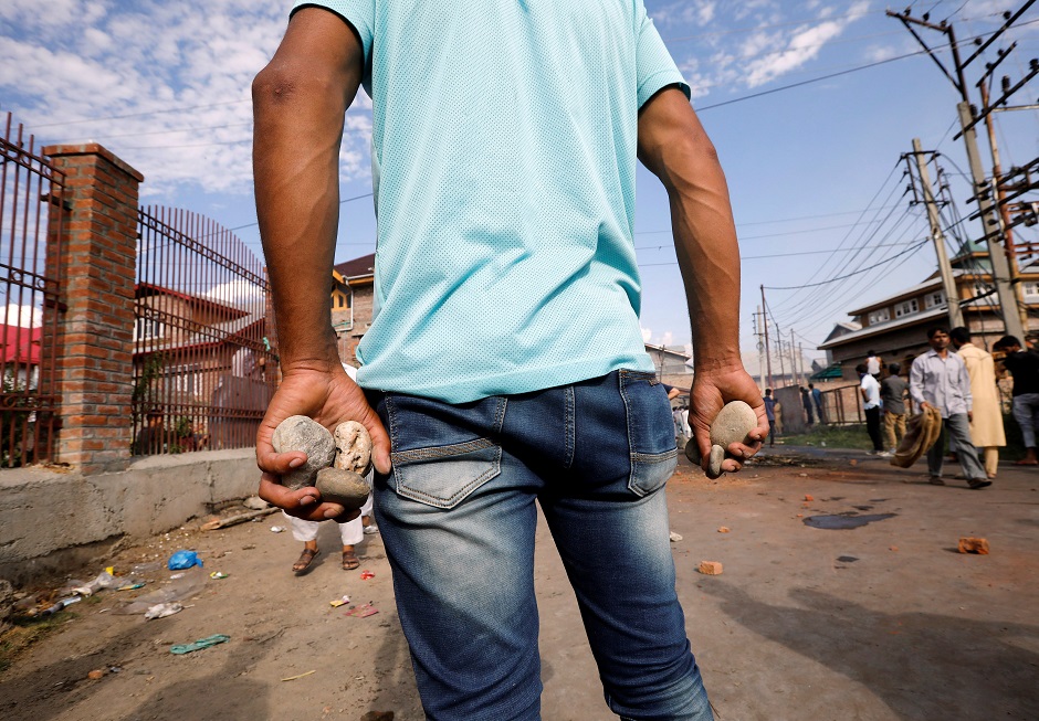 A Kashmiri man holds stones during clashes with Indian security forces, after scrapping of the special constitutional status for Kashmir by the Indian government, in Srinagar. PHOTO: REUTERS