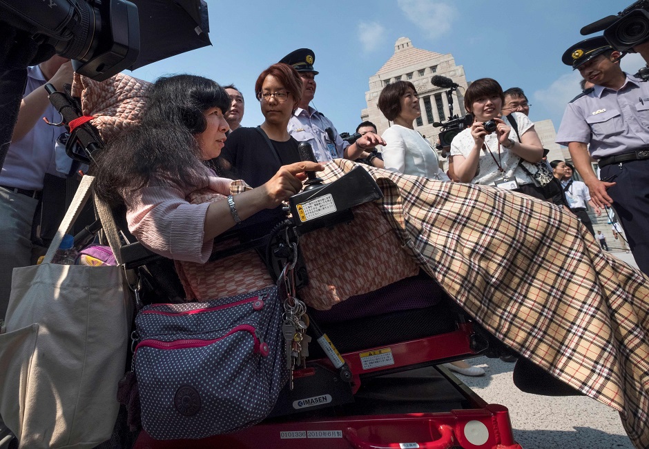 Wheelchair-bound Japanese lawmaker Eiko Kimura (L) arrives at Parliament in Tokyo. - Two lawmakers with serious paralysis took their seats in Japan's upper house on August 1 to cheers from supporters, marking the first time people with severe disabilities have served in the body. PHOTO: AFP