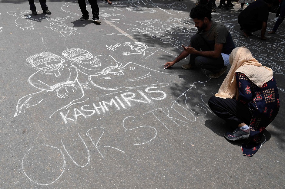 Communist Party of India (CPI) activists draw graffiti on the ground during a protest in New Delhi on August 7, 2019, in reaction to the Indian government scrapping Article 370 that granted a special status to Jammu and Kashmir. PHOTO: AFP