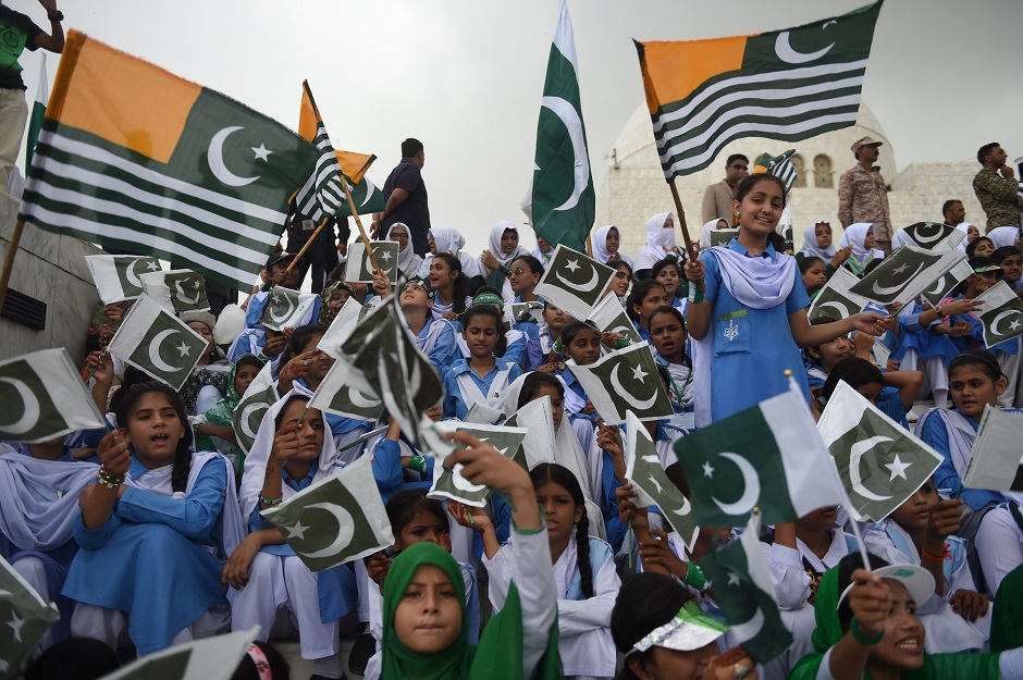 Girls sing the national anthem as they wave Pakistani and Pakistan-administered Kashmir flags outside the mausoleum of Quaid-e-Azam Mohammad Ali Jinnah. (Photo: Rizwan Tabassum / AFP)