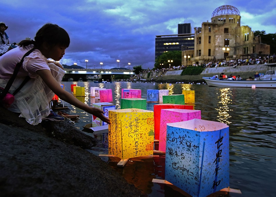 This August 6, 2019 picture shows a girl floating lanterns to mourn atomic bomb victims on the Motoyasu river beside the atomic bomb dome during the 74th anniversary of the atomic bombing in Hiroshima. PHOTO: AFP