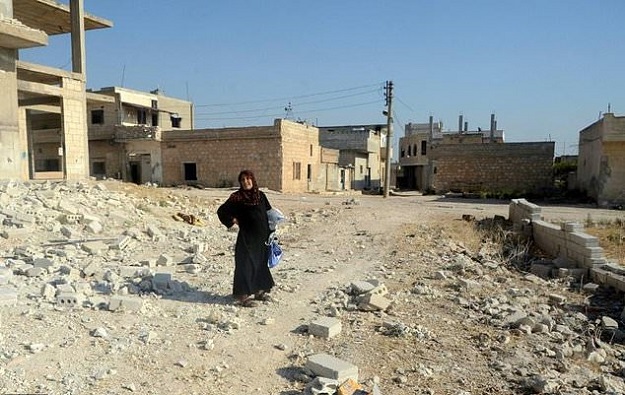 A woman stands in the ruins of Khan Sheikhun, a town almost entirely bereft of civilians after Syrian government forces took full control. PHOTO: AFP