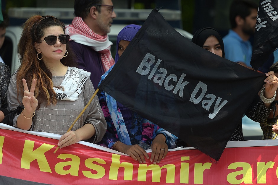 A protester of the All Parties Hurriyat Conference (APHC) holds a back flag near the Indian High Commission during a protest rally in Islamabad as they observe a 'Black Day' on India's Independence Day over the recent move to strip Indian-administered Kashmir of its autonomy. PHOTO: AFP