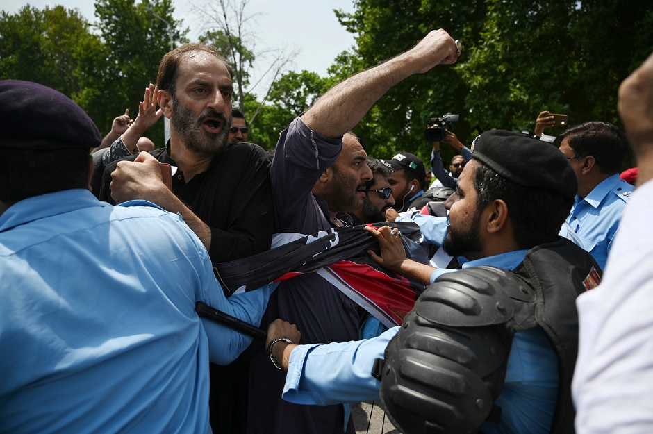 Riot policemen try to stop protesters of the All Parties Hurriyat Conference (APHC) during a rally near the Indian High Commission in Islamabad. PHOTO: AFP