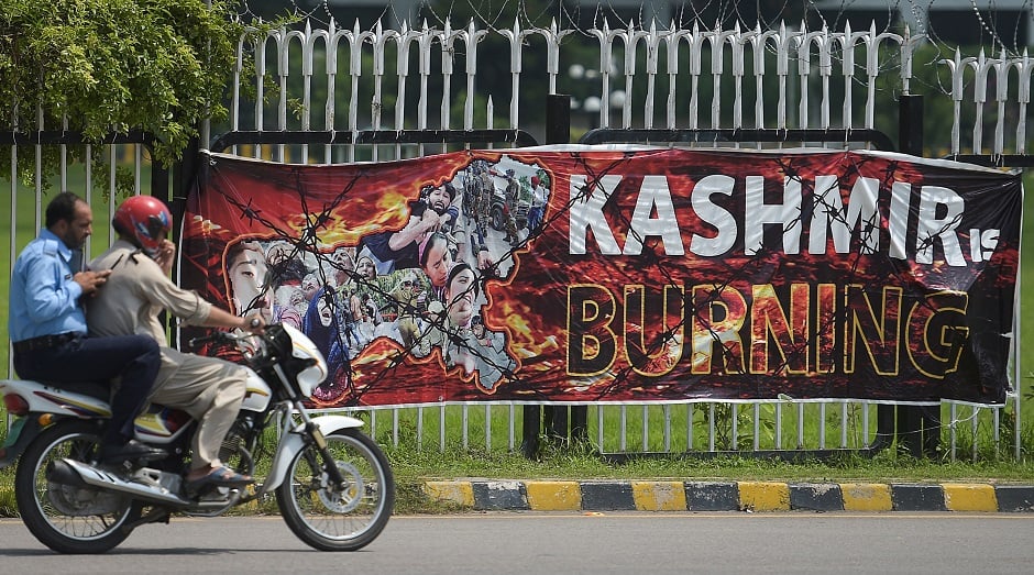 Policemen ride past a banner hanged near the Parliament building in Islamabad on August 15, 2019, as the country observes 'Black Day'. PHOTO: AFP