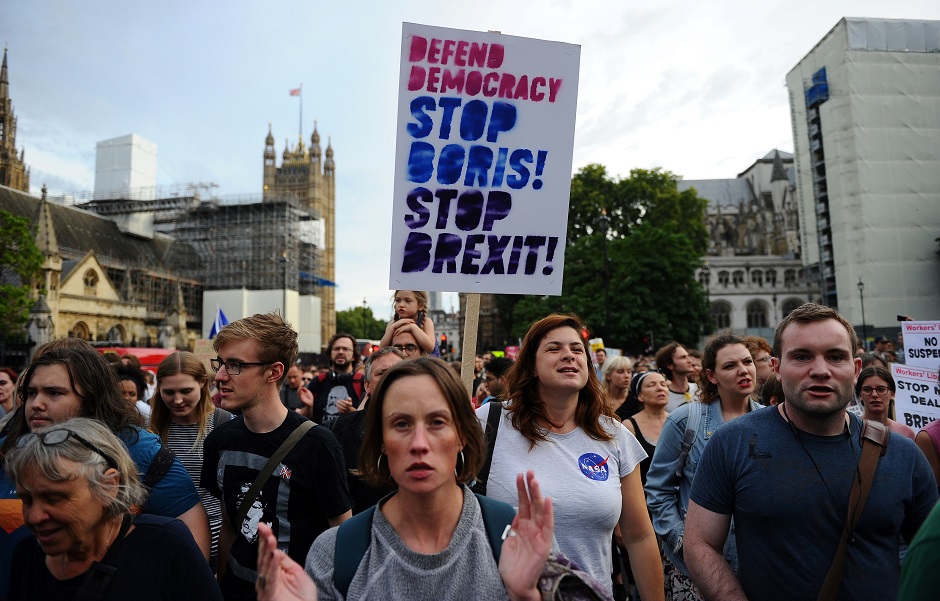 Anti-Brexit demonstrators hold placards as they take part in a protest march from Britain's Houses of Parliament to Downing Street in London. PHOTO: AFP