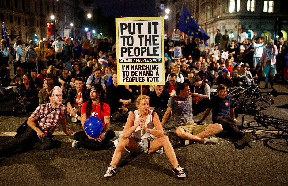 A demonstrator holds a banner, during an anti-Brexit protest, outside the Houses of Parliament in London. PHOTO: Reuters