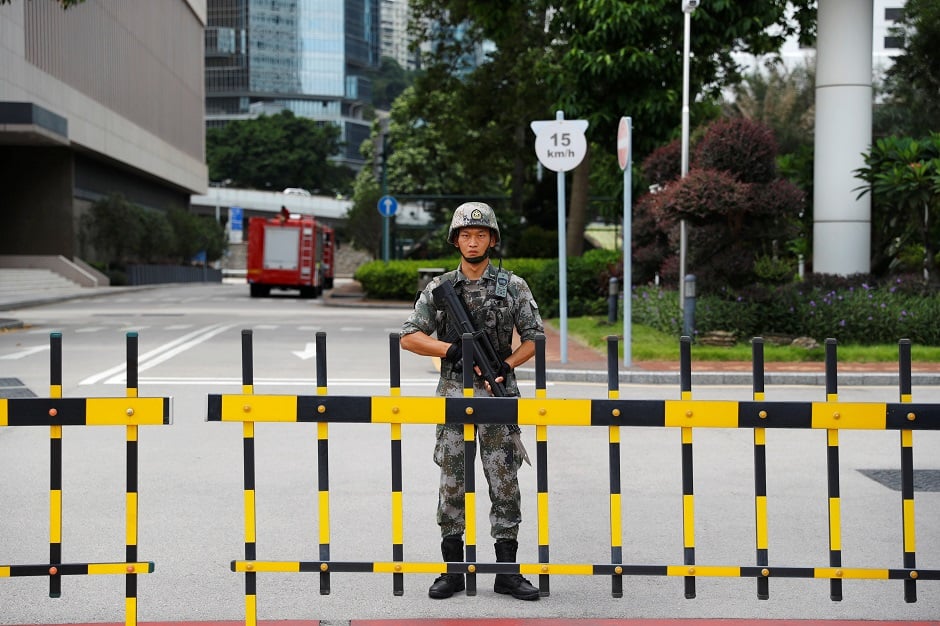 A Chinese People's Liberation Army (PLA) soldier guards the entrance to the PLA Hong Kong Garrison headquarters in the Central Business District in Hong Kong. PHOTO: Reuters