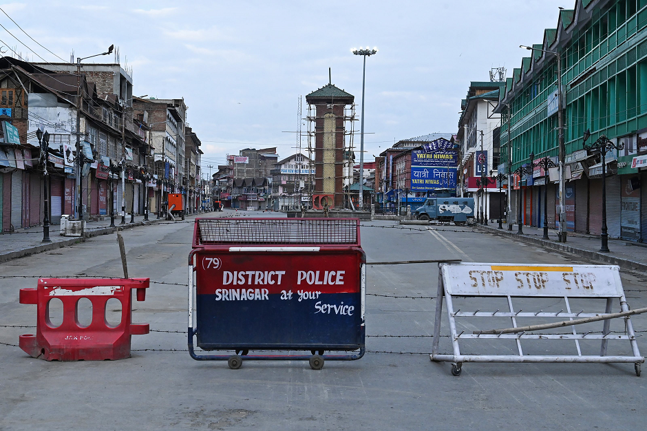 Security personnel (back) stand guard a street under the clock tower at Lalchowk during a lockdown in Srinagar on August 12, 2019. PHOTO: AFP