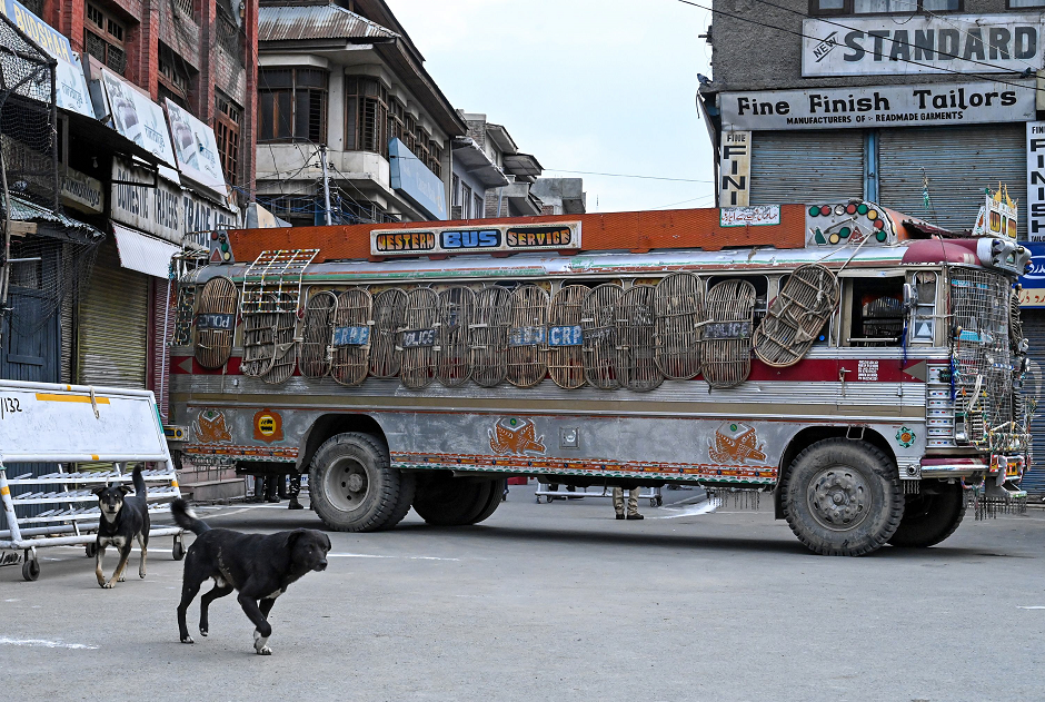 A security personnel vehicle blocks a road as stray dogs walk by during a lockdown in Srinagar on August 12, 2019. PHOTO: AFP