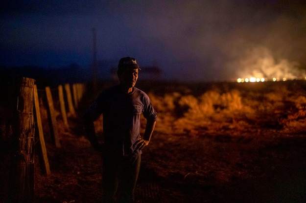 Brazilian Neri dos Santos, 48, looks at a fire at the farm where he works in Nova Santa Helena municipality, Mato Grosso state, in the Amazon basin, Brazil. PHOTO: AFP