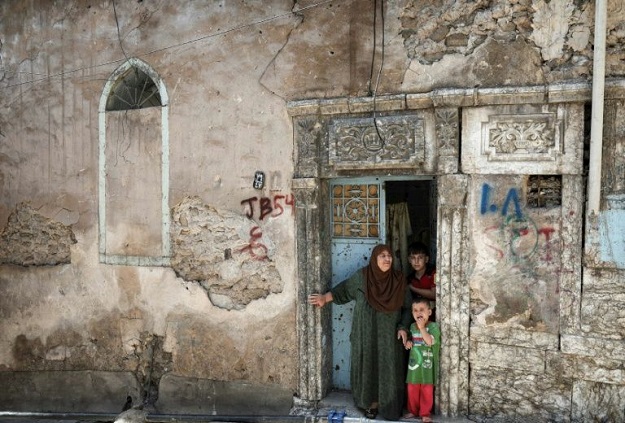 Sabiha Jassem, 61, stands in the doorway of her home in west Mosul (Photo: AFP)