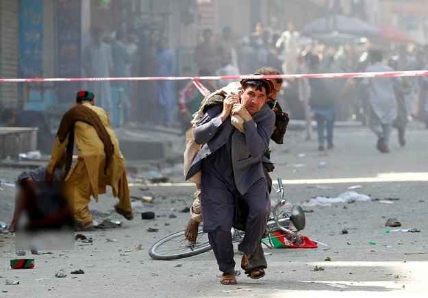 A man caries a wounded person to the hospital after a blast in Jalalabad, Afghanistan. Photo: Reuters