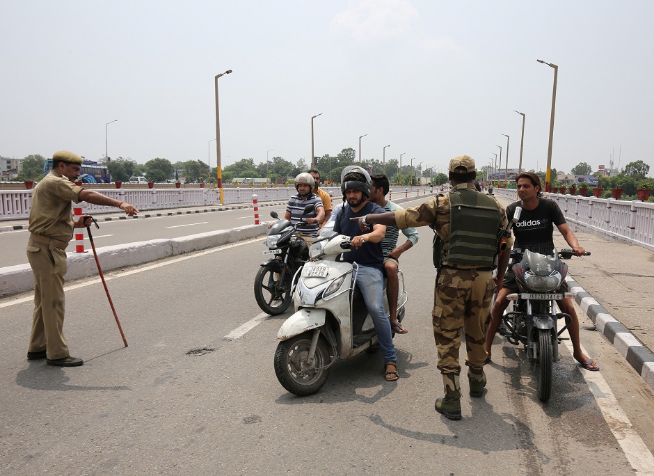 Indian security personnel stop residents during restrictions in Jammu, August 5, 2019. (Photo: REUTERS/Mukesh Gupta)