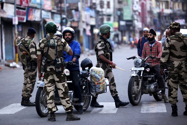 Indian security personnel question motorists on a street in occupied Jammu. -AFP