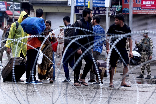 People make their way along a street in occupied Jammu. -AFP 