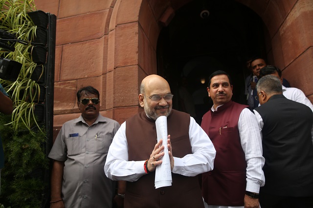 India's Home Minister Amit Shah greets the media upon his arrival at the parliament in New Delhi. -Reuters