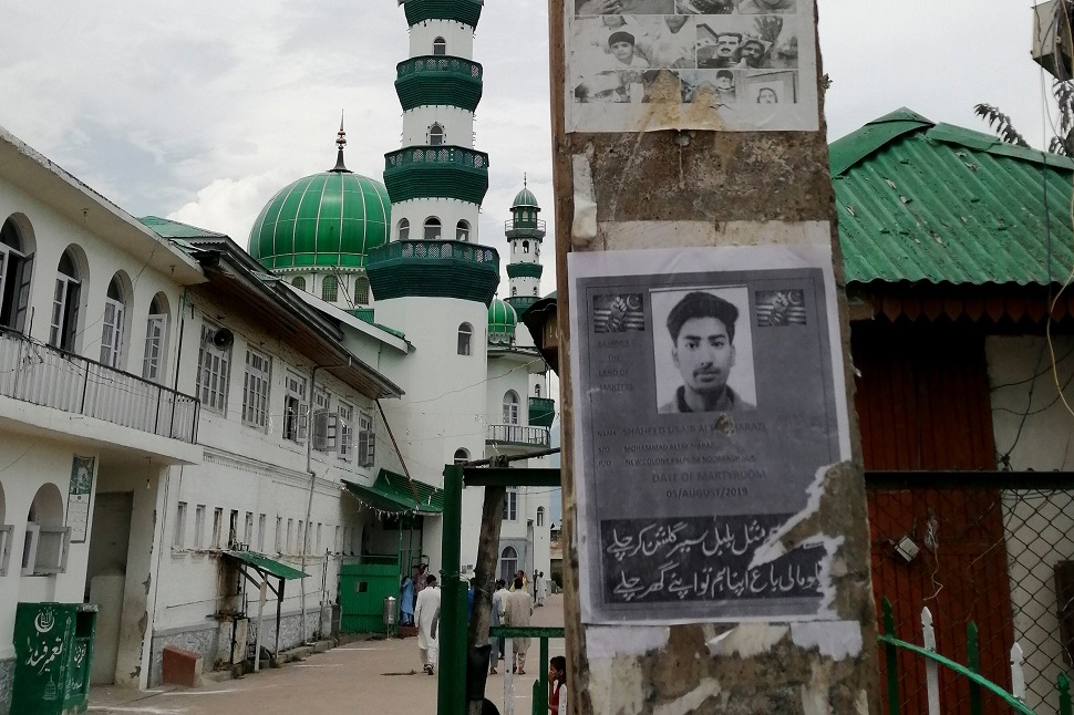 This picture taken on August 16, 2019, shows a poster of Kashmiri youth Usiab Ahmad, who died from drowning on August 5 after an alleged encounter with Indian government forces, near the Asar Shareef Jenab Saheb Mosque in the Soura locality of Srinagar. PHOTO: AFP