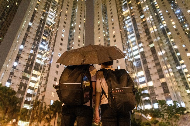 Abby, 19, and her boyfriend Nick, 20, pose in front of residential buildings after they attended a protest in Tsuen Wan, an area in the New Territories in Hong Kong. (Photo: AFP)