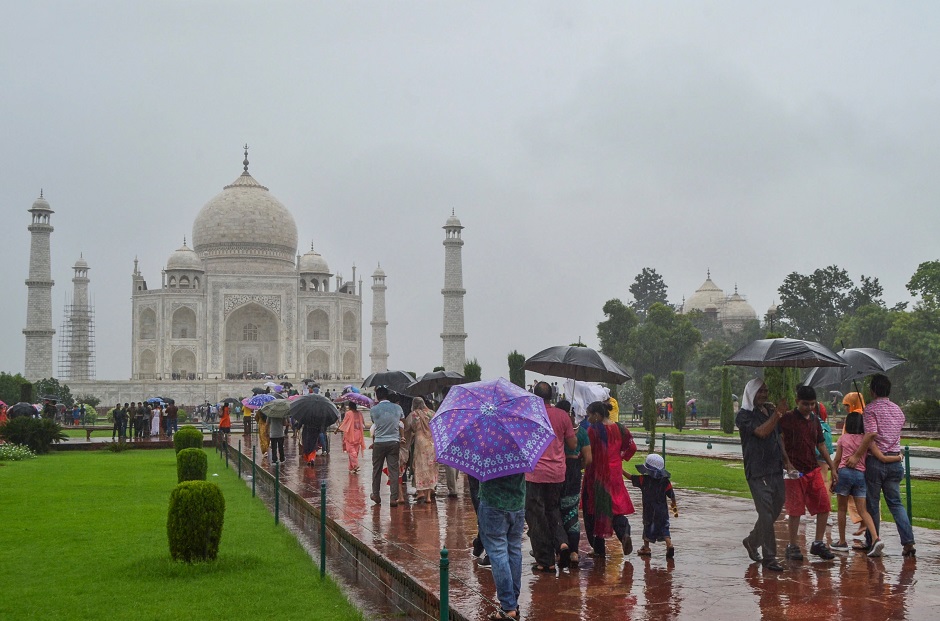 Tourists hold umbrellas as they visit the Taj Mahal under heavy rain in Agra. PHOTO: AFP