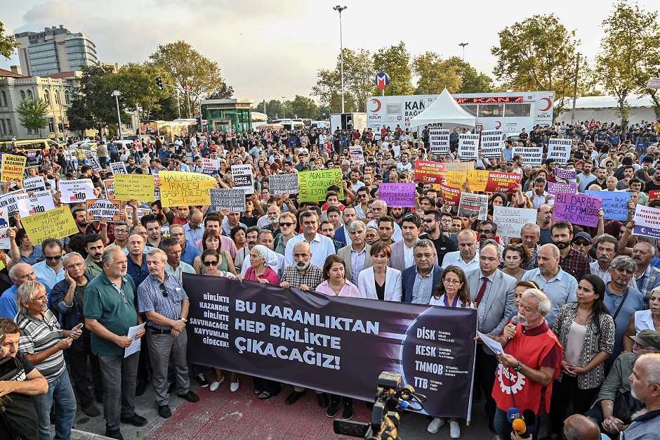 Demonstrators hold a banner reading 'We will get out of this darkness all together' during a protest against the replacement of Kurdish mayors with state officials in three cities. PHOTO: AFP