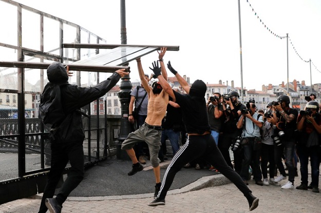 Protesters tear down a part of a barricade put up by French police in Bayonne. (Photo: AFP)