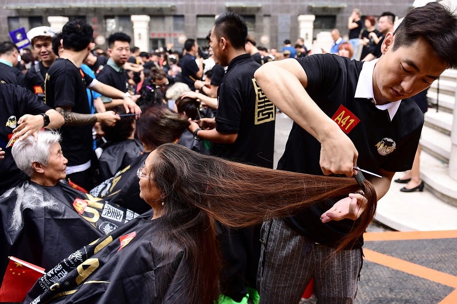 Some 1,400 hairdressers give haircuts as they attempt a Guinness world record for the largest number of people cutting hair at the same time in Shenyang, China's northeastern Liaoning province. PHOTO: AFP