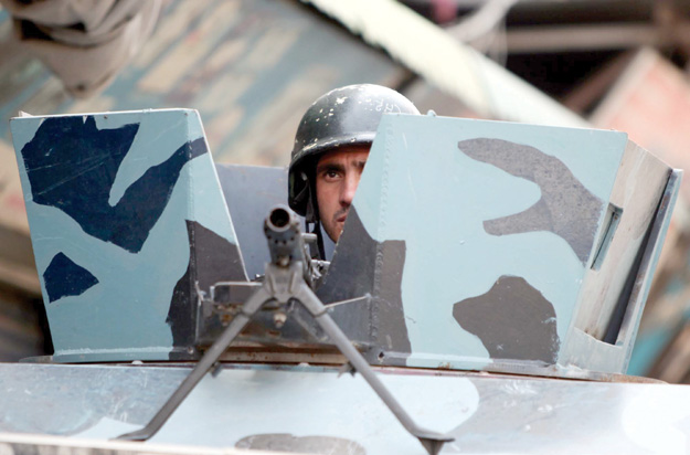 A police officer peeks from an armoured car in Peshawar. PHOTOS: APP/PPI