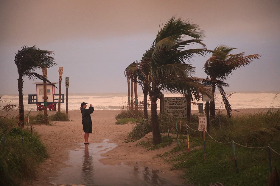 A woman takes a picture as the effects of Hurricane Dorian. PHOTO: AFP