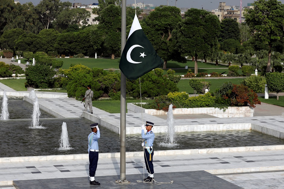 A Pakistan's national flag flies on mast as the members of the Pakistan Air Force march at the mausoleum of Muhammad Ali Jinnah during Defence Day ceremonies. PHOTO: Reuters
