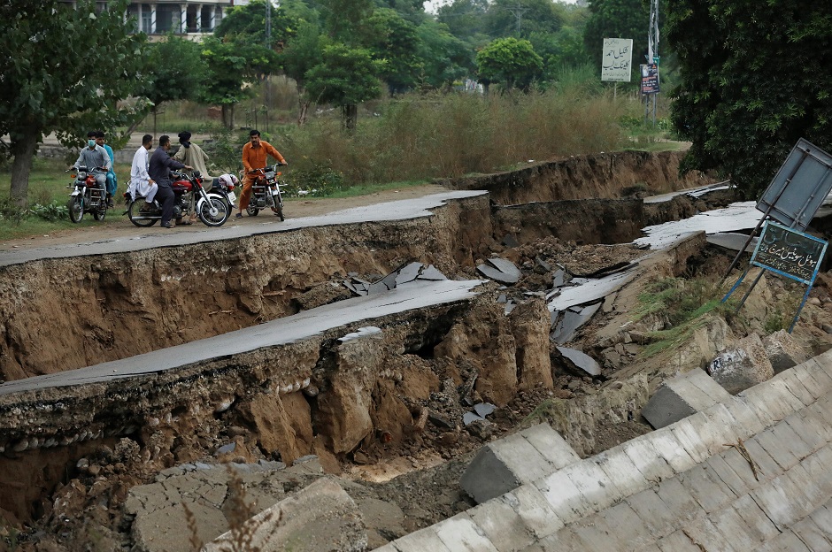  People on bikes gather near a damaged road after an earthquake in Mirpur, Pakistan. PHOTO: Reuters 
