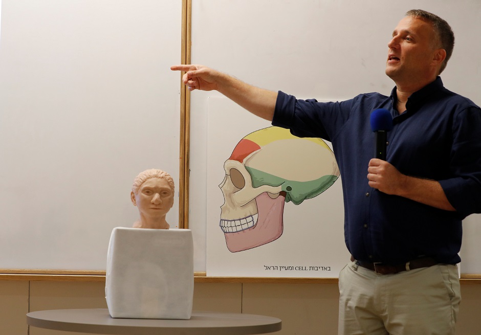 Hebrew University professor Liran Carmel, gestures next to the artistic rendering of the head and face of the skeleton. PHOTO: REUTERS