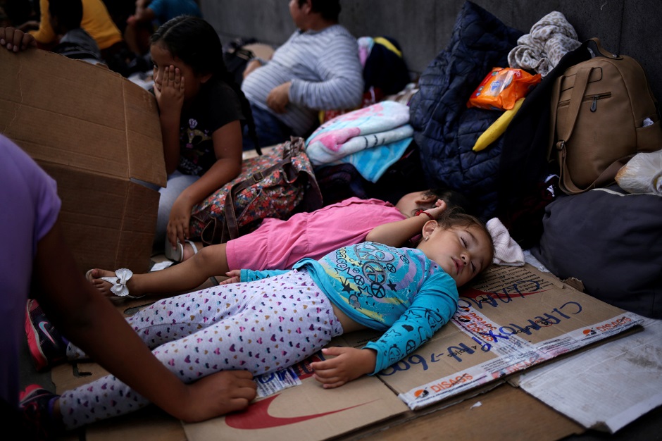 Mexican girls rest while queue with her parents to cross into the US to apply for asylum at Paso del Norte border. PHOTO: Reuters