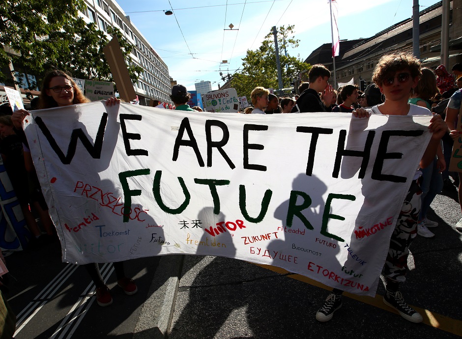 Activists hold a banner during a pro-climate demonstration march in Lausanne. PHOTO: Reuters