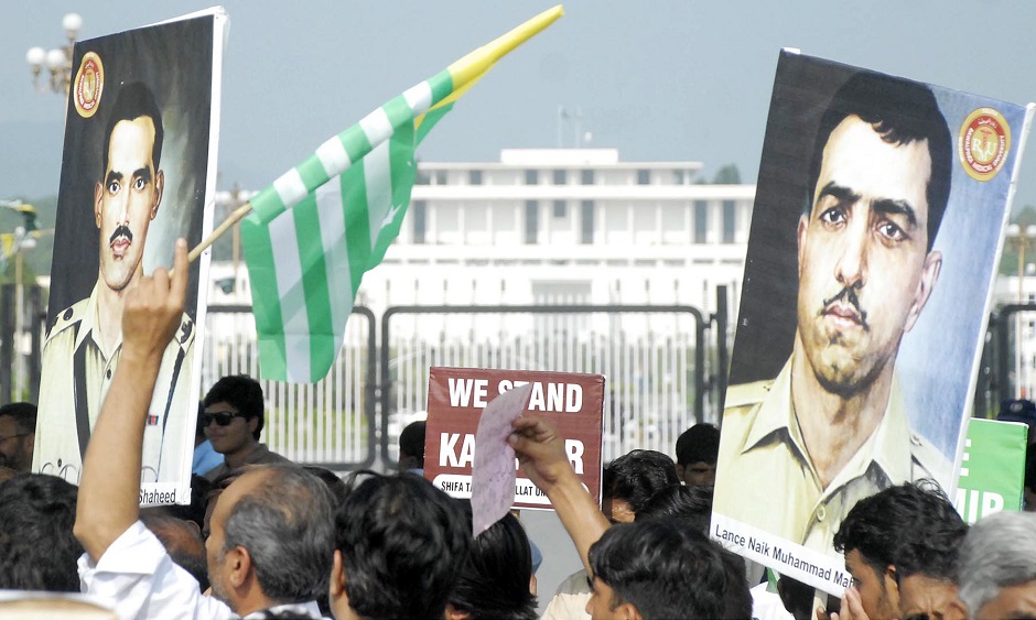 Members of civil society hold portraits of Pakistan Army martyrs  at Jinnah Avenue in federal capital. PHOTO: ONLINE