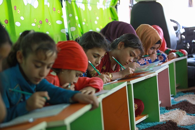 Displaced Syrian children take lessons on the bus (Photo: AFP)