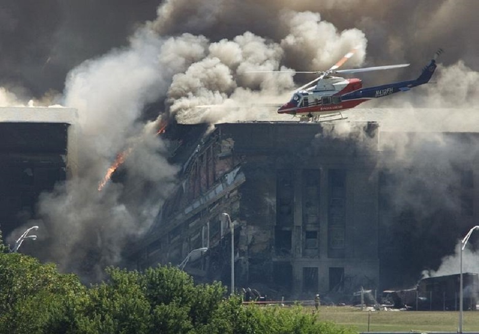 A rescue helicopter surveys damage to the Pentagon as firefighters battle flames after a hijacked airplane crashed into the U.S. military headquarters outside of Washington. PHOTO: Reuters 