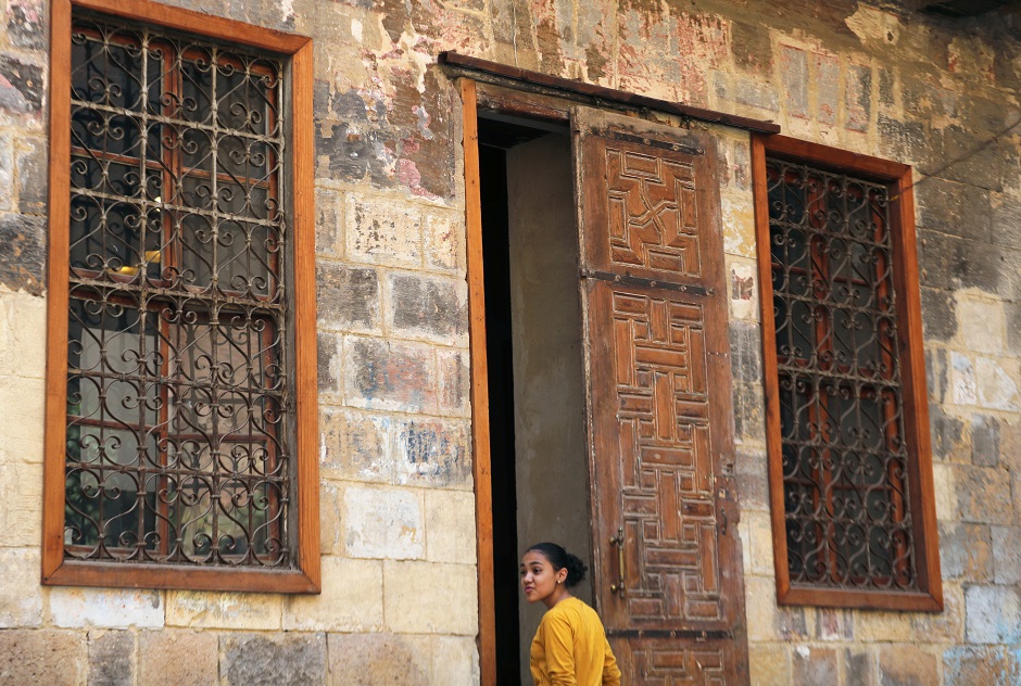  A young woman stands in front of an old wooden door by a historic house in Darb al-Ahmar neighbourhood in Cairo, Egypt August 31, 2019. PHOTO: REUTERS