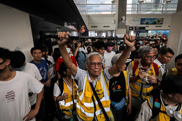 'Grandpa Wong', 85, shielding protesters from the police by holding his walking stick up along with other 