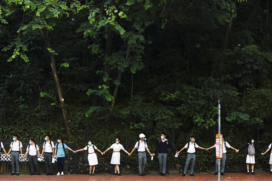  Secondary school students hold hands as they form a human chain in Hong Kong, China. PHOTO: Reuters