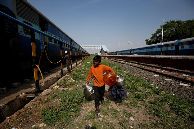 Siddharth Dhage, 10, carries empty water containers along railway tracks at Aurangabad railway station, in Aurangabad. PHOTO: Reuters