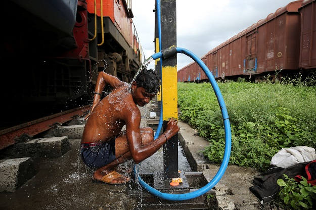 Prakash Nagre washes himself at Aurangabad railway station. PHOTO: Reuters