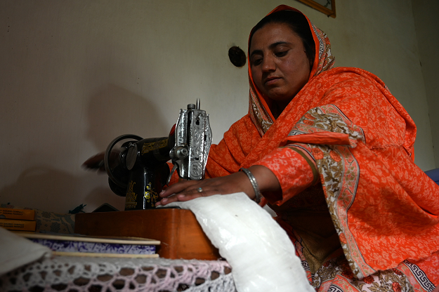 In this picture taken on May 18, 2019, Pakistani woman Hajra Bibi makes a sanitary pad with a sewing machine at her home in Booni village in Chitral. PHOTO: AFP