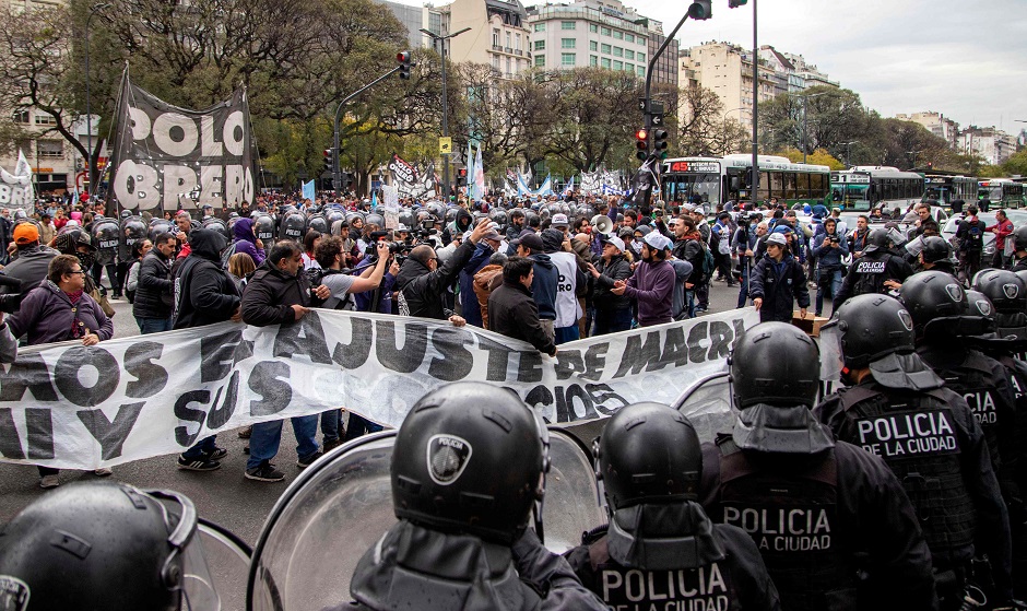Protesters surrounded by riot police outside the Social Development Ministry building in Buenos Aires. PHOTO: AFP