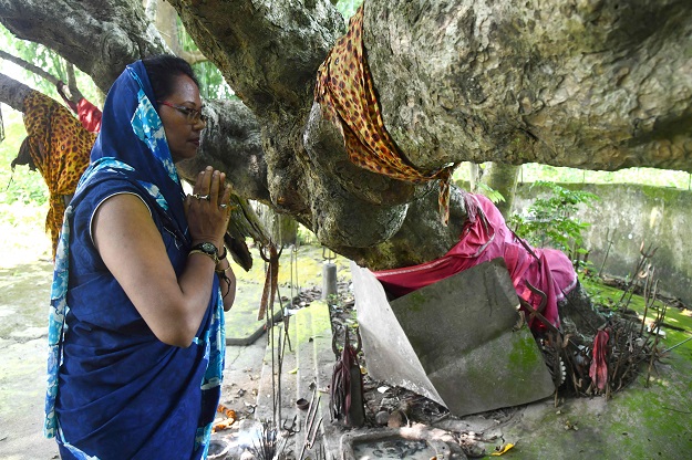 Bonti Das, a Hindu devotee, offering prayers at a shrine taken care of by a Muslim. PHOTO: AFP